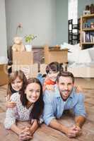 Portrait of smiling family lying on hardwood floor