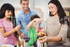 Happy family preparing fruit juice