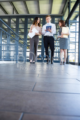 Three confident colleagues discussing in office Three confident colleagues discussing in office
