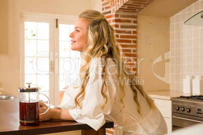 Pretty woman day dreaming leaning on the counter