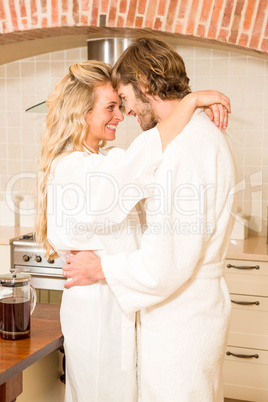 Cute couple cuddling in bathrobes