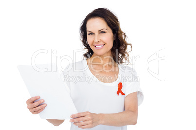 Woman wearing red aids awareness ribbon reading test result