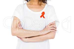 Woman wearing red aids awareness ribbon crossing arms