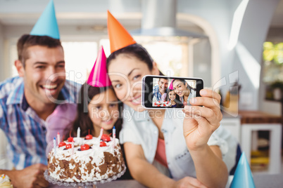 Cheerful family taking selfie during birthday celebration