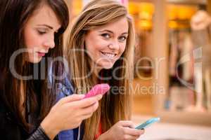 Two beautiful women using their phone