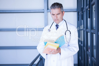 Male doctor reading medical book