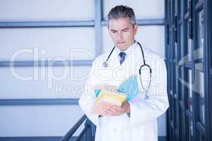 Male doctor reading medical book