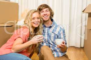 Cute couple sitting on the floor while drinking