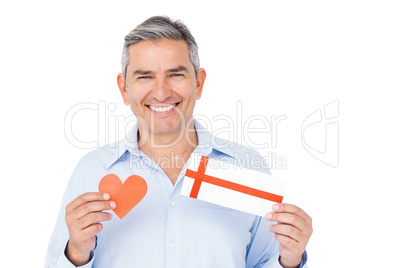 Handsome man showing present and paper heart