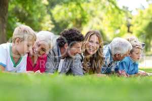 Family with dog lying on the grass in the park