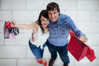 Portrait of smiling couple showing shopping bags