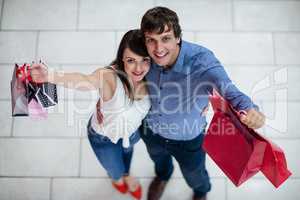 Portrait of smiling couple showing shopping bags