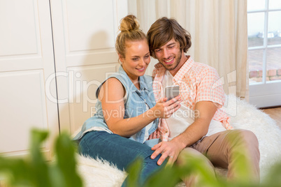 Cute couple looking at smartphone screen