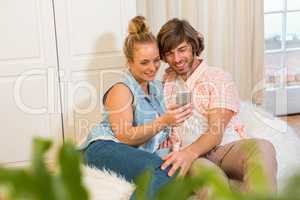 Cute couple looking at smartphone screen