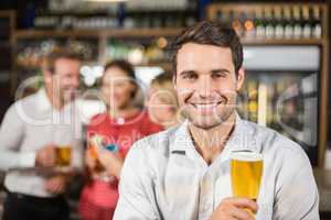 Man smiling at camera holding a beer