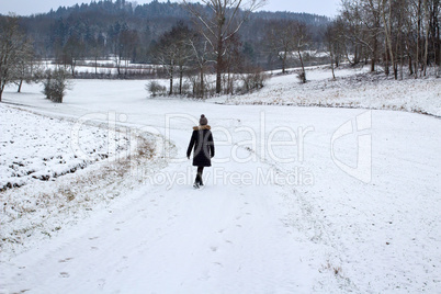 Woman taking a walk in snowy winter landscapes