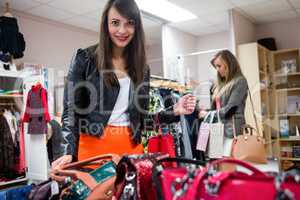 Women selecting bags and clothes while shopping