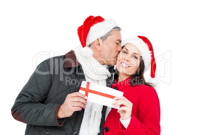 Festive couple holding christmas gift and kissing