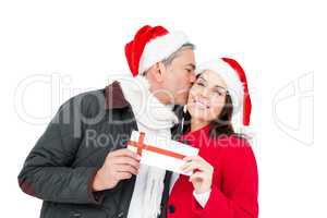 Festive couple holding christmas gift and kissing