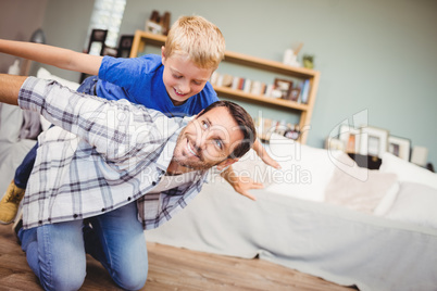 Father and son smiling while playing at home