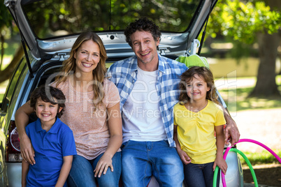 Smiling family sitting in the luggage space