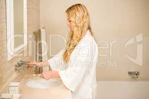 Blonde woman about to brush her teeth