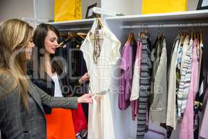 Women selecting a dress while shopping for clothes