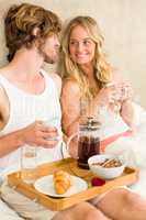 Cute couple having breakfast in bed