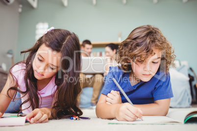 Children studying while parents in background