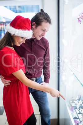 Couple in Christmas attire looking at wrist watch display