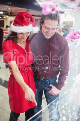 Couple in Christmas attire looking at wrist watch display