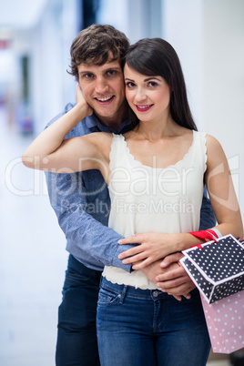 Portrait of couple embracing in mall