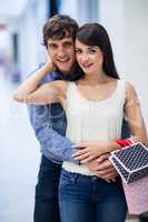 Portrait of couple embracing in mall