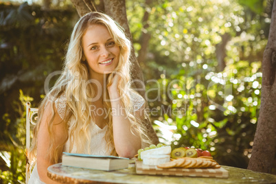 Beautiful blonde relaxing with a book and food