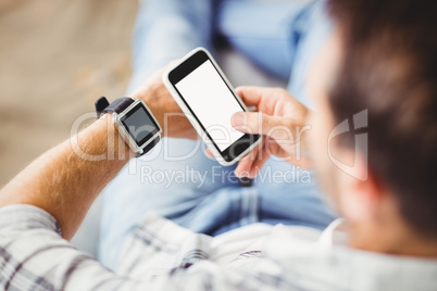 Man wearing smart watch and using mobile phone
