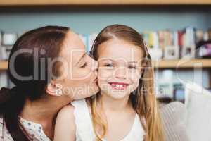 Close-up of mother kissing happy daughter