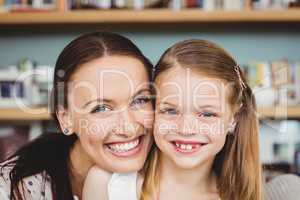 Portrait of cheerful mother embracing daughter