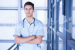 Serious male doctor standing with arms crossed