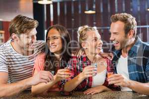 Friends laughing with shots in hand