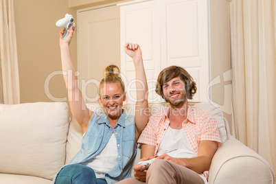 Cute couple playing video games sitting on the couch