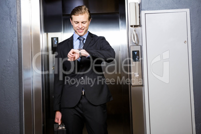 Businessman checking time in elevator