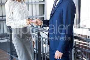 Businessman giving credit card to businesswoman