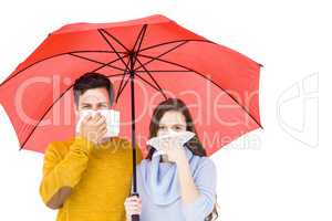 Couple blowing their noses under an umbrella