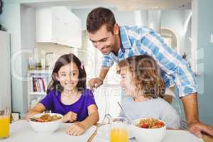 Happy man with children having breakfast