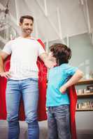 Cheerful father and son in superhero costume