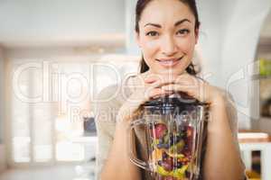 Portrait of happy woman preparing fruit juice