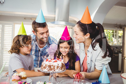 Family with cake at table during birthday celebration