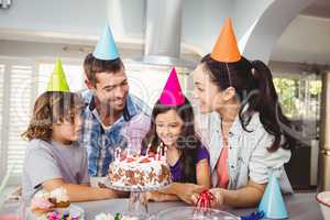 Family with cake at table during birthday celebration