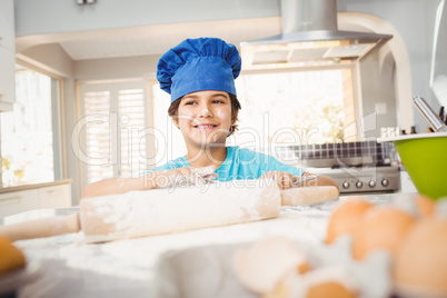 Boy smiling while preparing food by table
