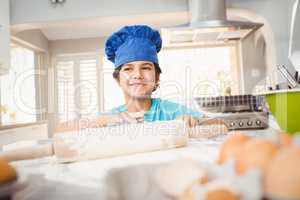 Boy smiling while preparing food by table